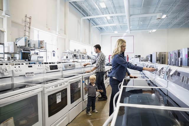 Young family shopping for stoves in appliance store