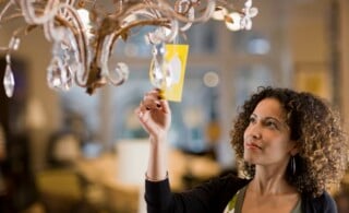 Woman Looking at Price Tag of Chandelier