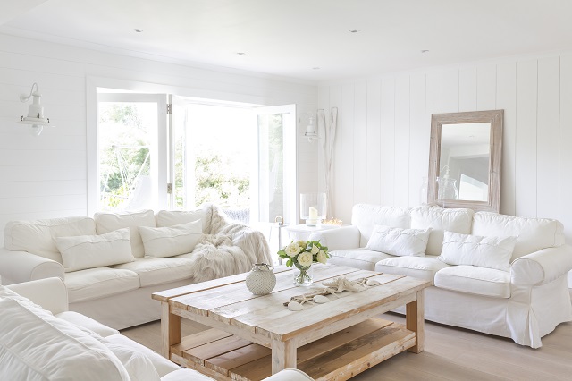 White living room with simple fabrics, distressed coffee table