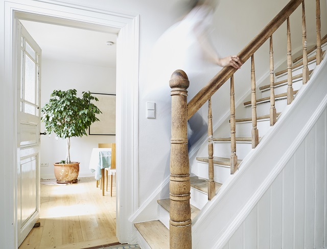 Man going upstairs on wooden stairs in an old country house