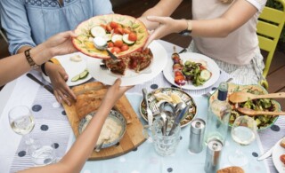 Friends sharing plates of vegetables and diet-friendly foods.