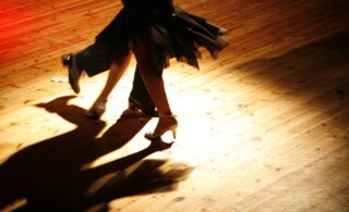 Tangoing couple alone on hardwood floor