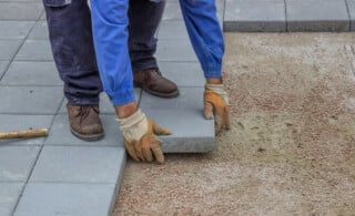 contractor lays pavers on patio