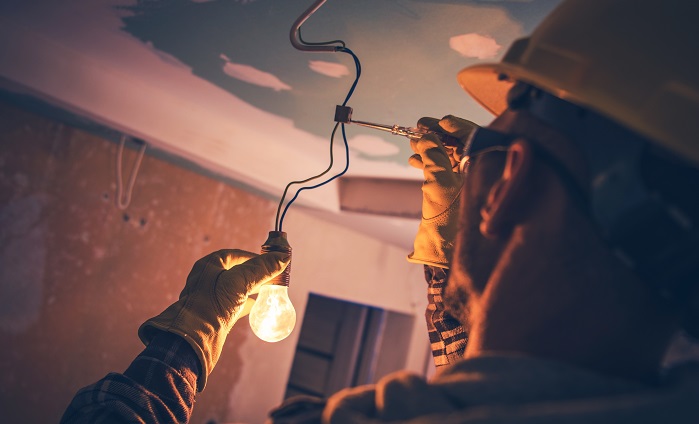 electrician repairing wiring for lighting in home