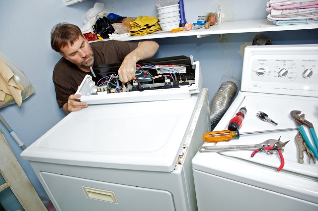 Appliance repair man fixing a clothes dryer