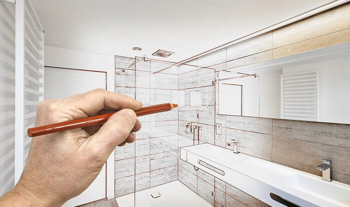 man draws plan for his bathroom remodel