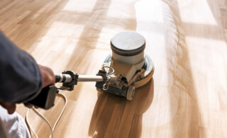 man buffer cleans laminate flooring