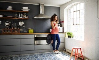 Pregnant woman in tidy modern kitchen in a renovated old building
