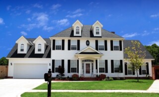 Two-story, colonial-style home with white siding and black shutters