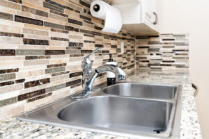 stainless steel sink in kitchen with backsplash