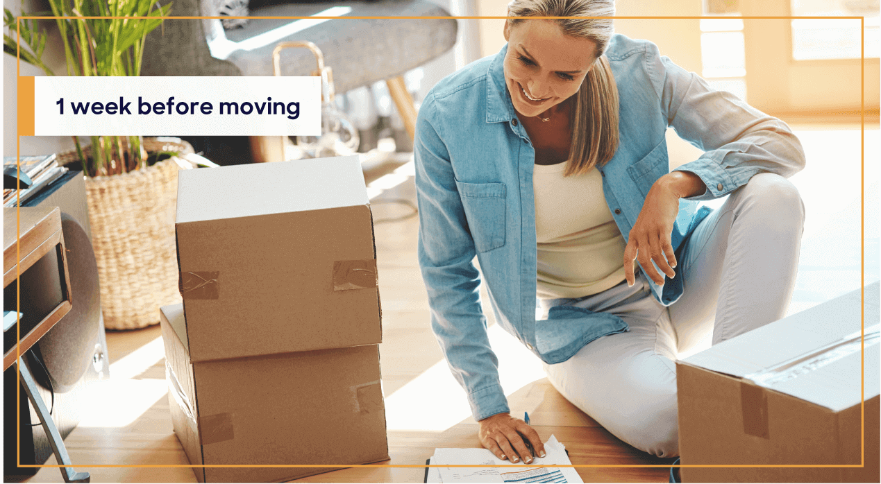 woman with a checklist surrounded by moving boxes