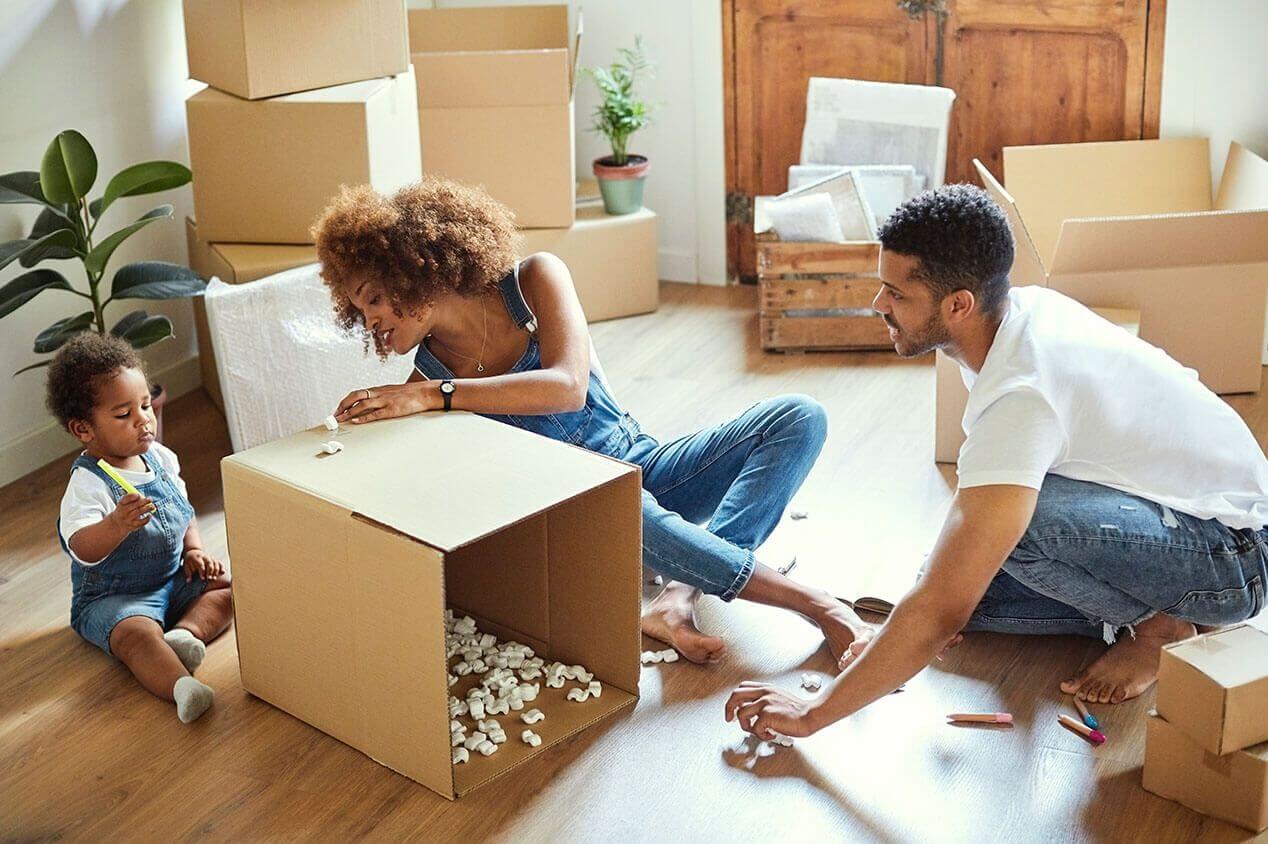 family of three moving with boxes