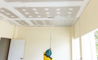 professional painter using roller on ceiling