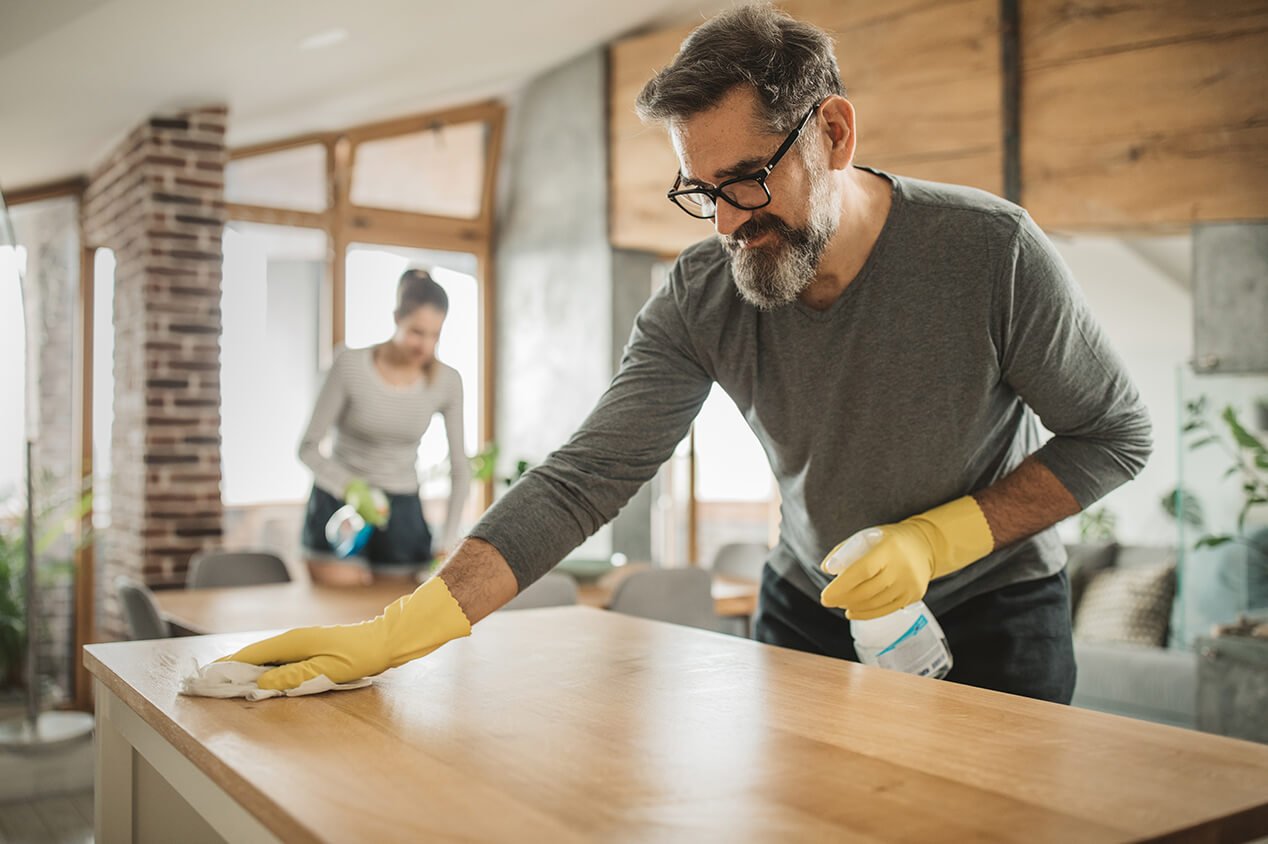 man cleaning dust from kitchen