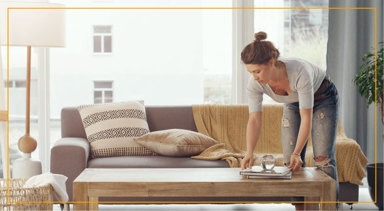 Woman organizing coffee table in living room