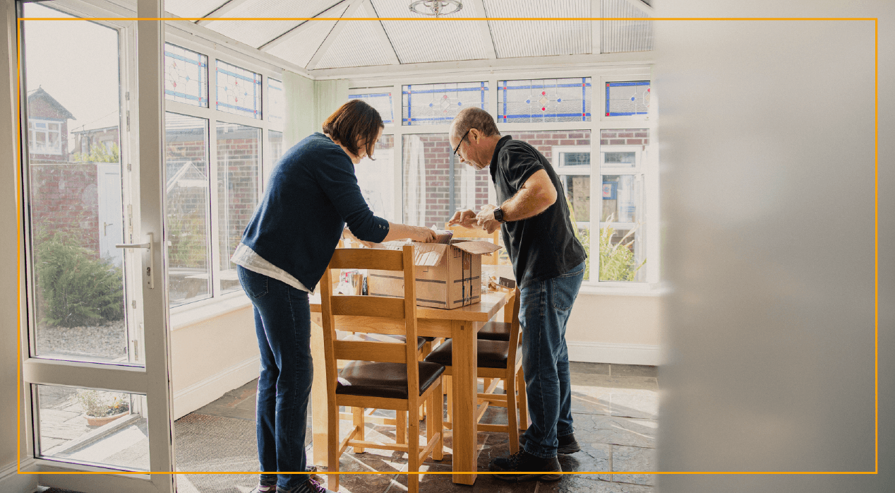 Man and woman opening a box at a table