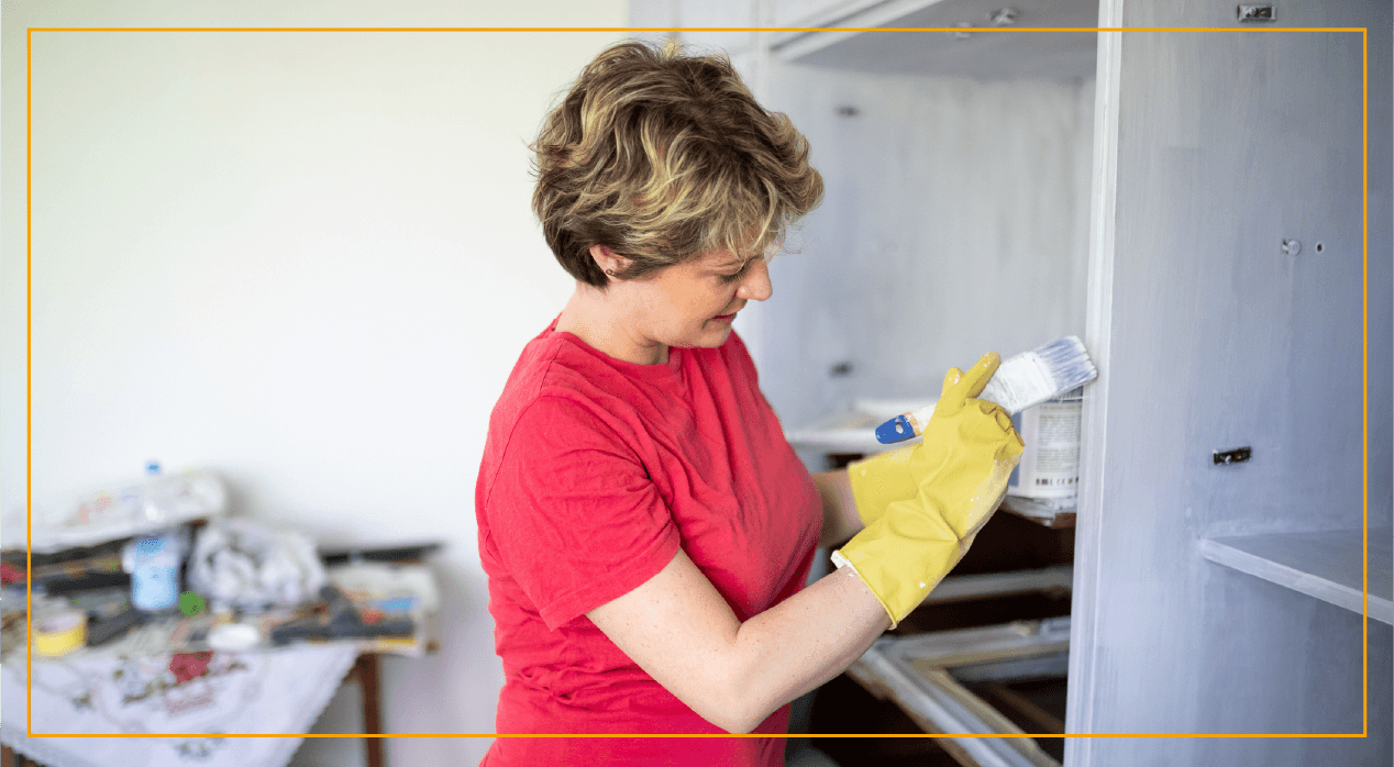 Woman painting a bookcase