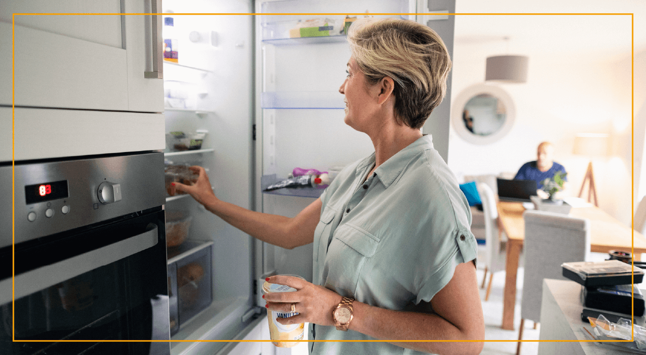 Woman smiling while she opens the fridge