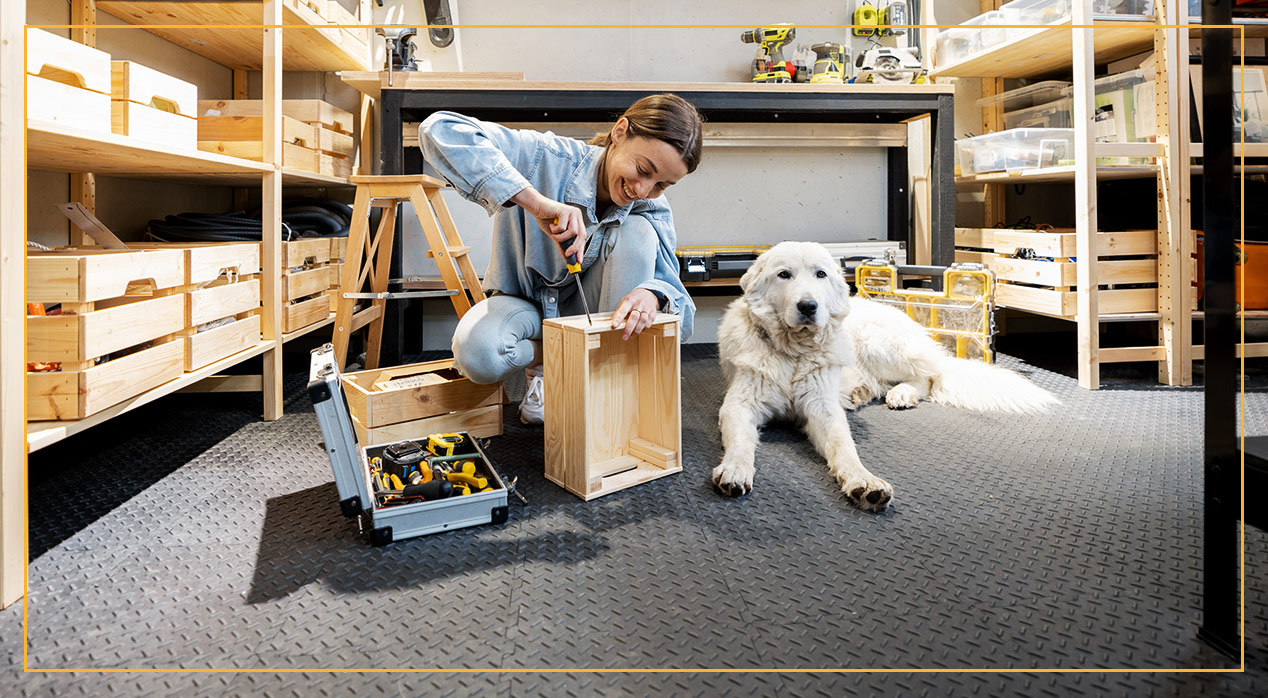 woman working in garage next to dog