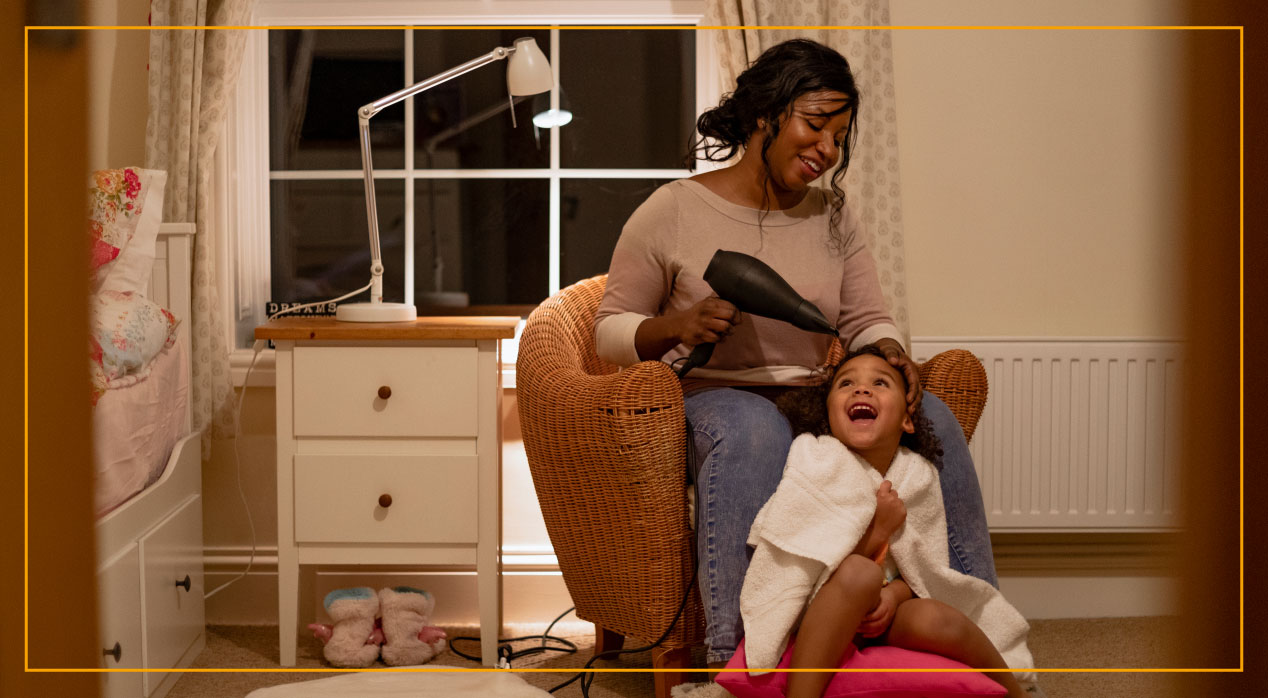 mom blowdrying her daughter's hair