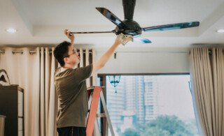 man cleaning ceiling fan