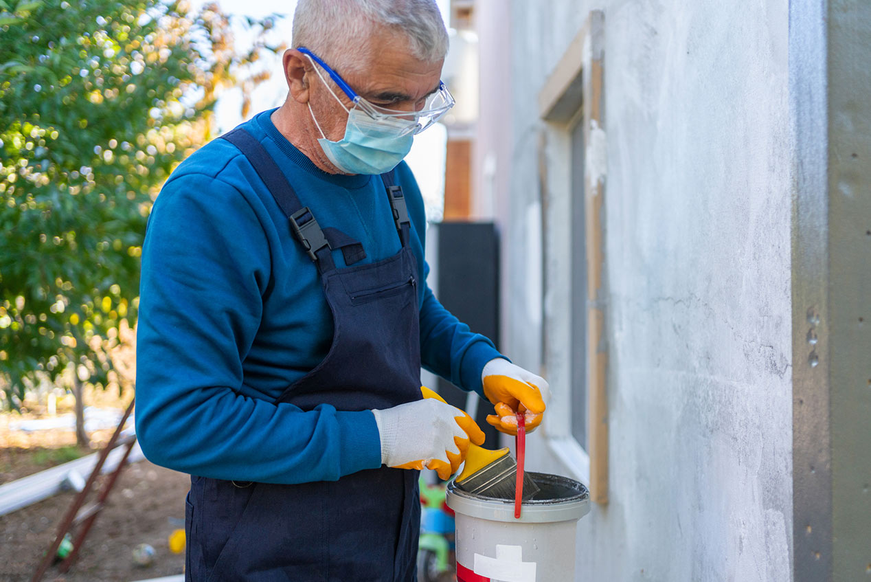 man painting home exterior