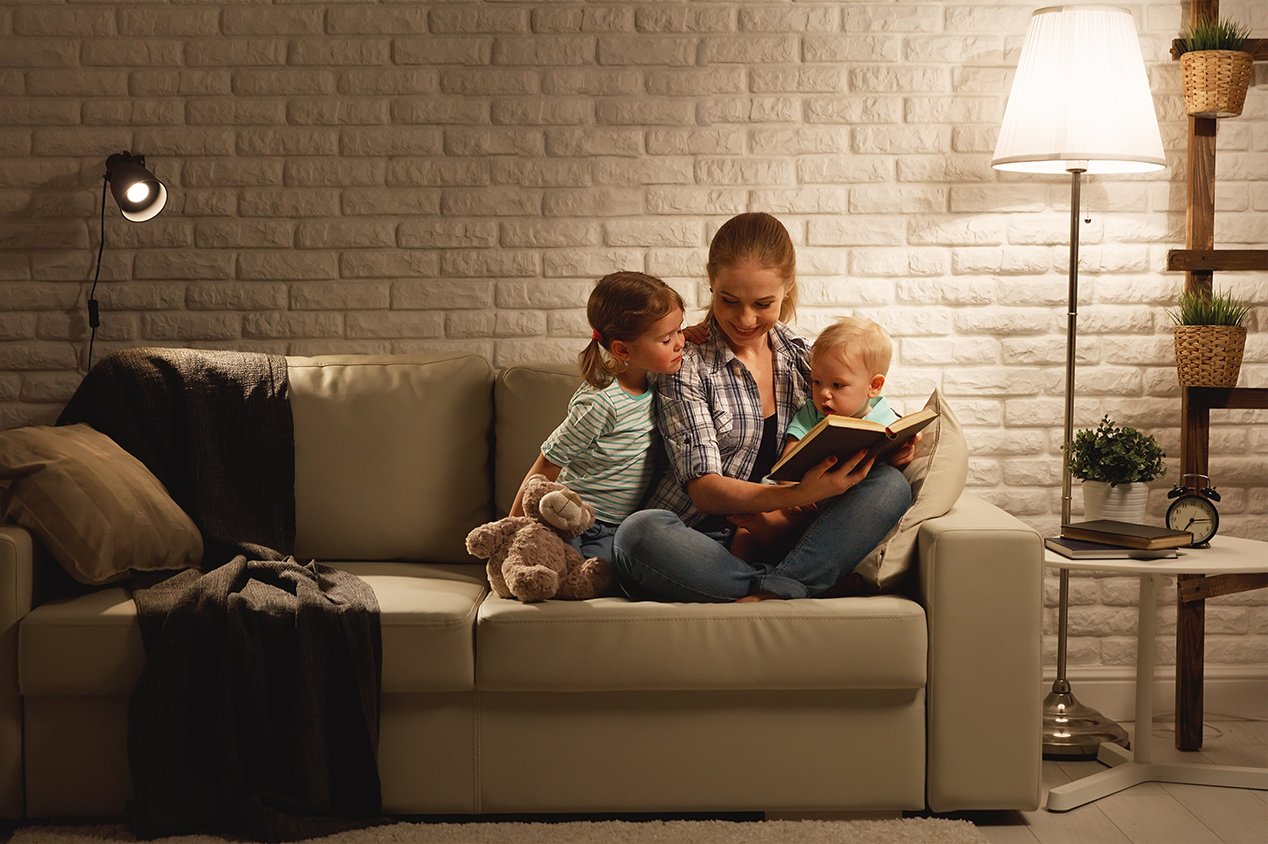 mother reading to children on couch