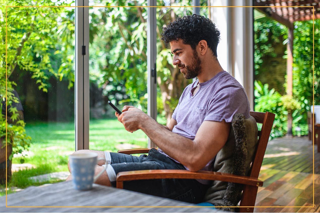 Man on patio looking at phone outside