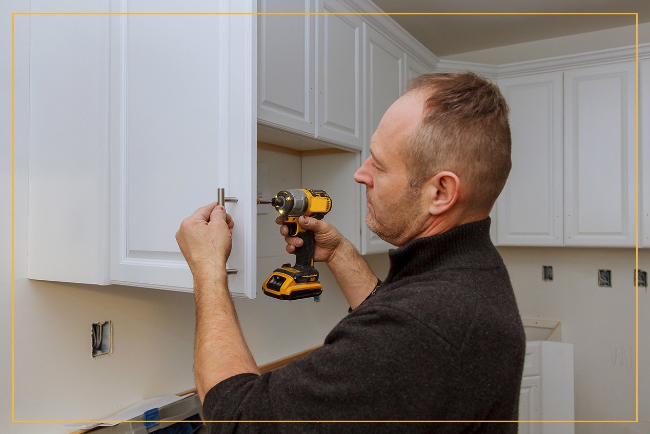 man installing cabinet hardware