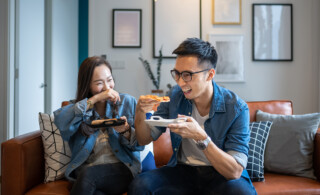 couple eating pizza on couch