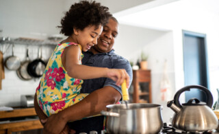 father and daughter making dinner in kitchen