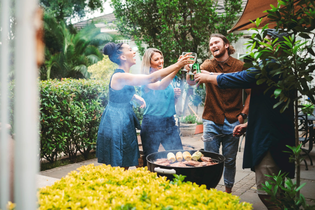 friends grilling out and toasting drinks in the backyard