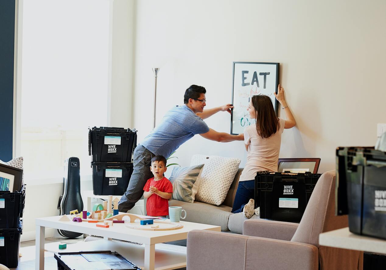 couple hanging photograph on wall