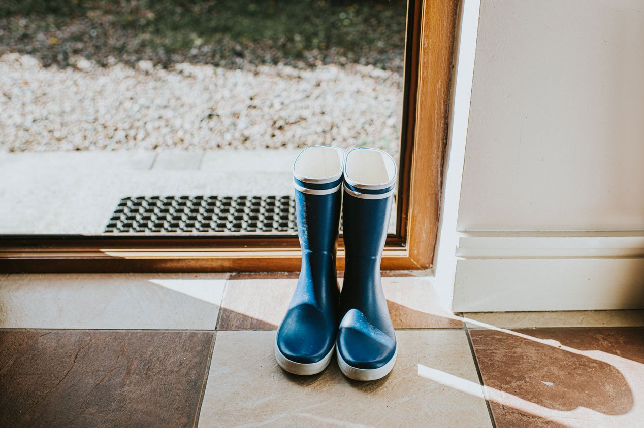 A pair of blue welly boots on a tile floor