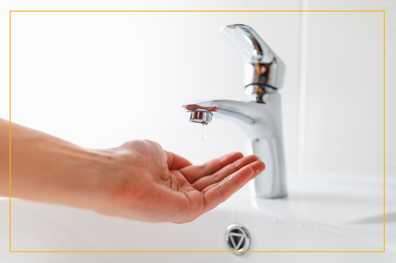 hand under dripping faucet