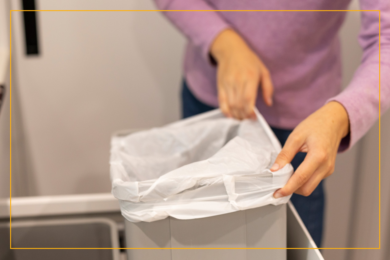 Person lifting trash can from drawer