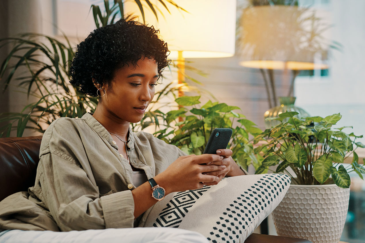 Woman lounging on couch looking at her phone