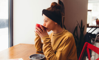 woman sipping coffee and looking out the window
