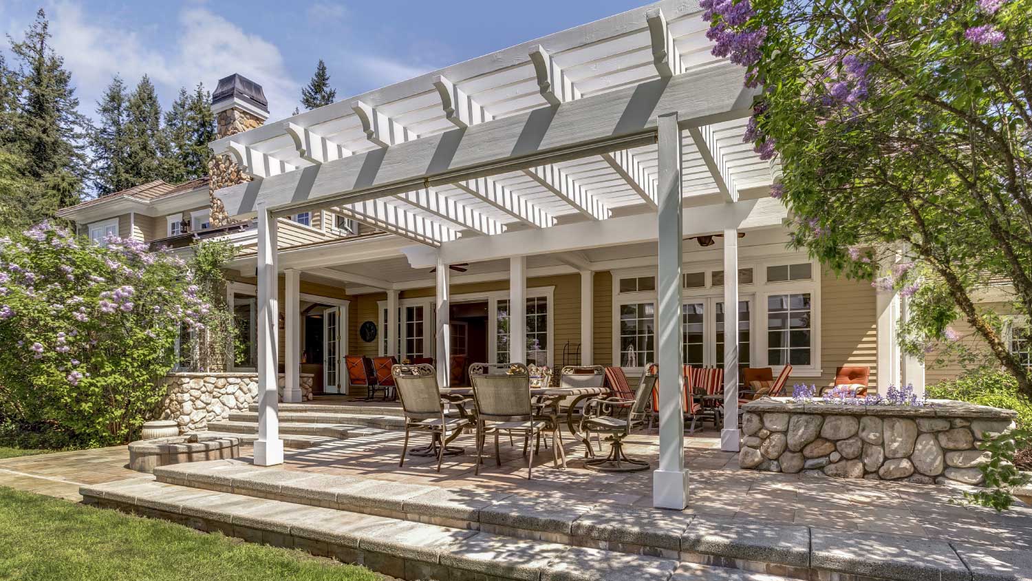 Outdoor deck patio space with white dining pergola